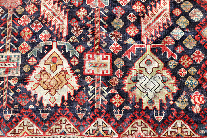 Unique 6x9 antique distressed Persian Qashqai tribal rug with navy background from a trusted dealer with over 45 years of experience.
