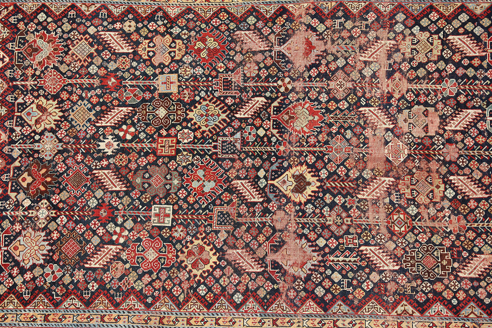 Unique 6x9 antique distressed Persian Qashqai tribal rug with navy background from a trusted dealer with over 45 years of experience.