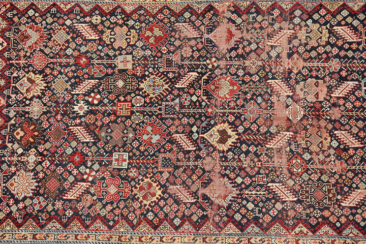 Unique 6x9 antique distressed Persian Qashqai tribal rug with navy background from a trusted dealer with over 45 years of experience.