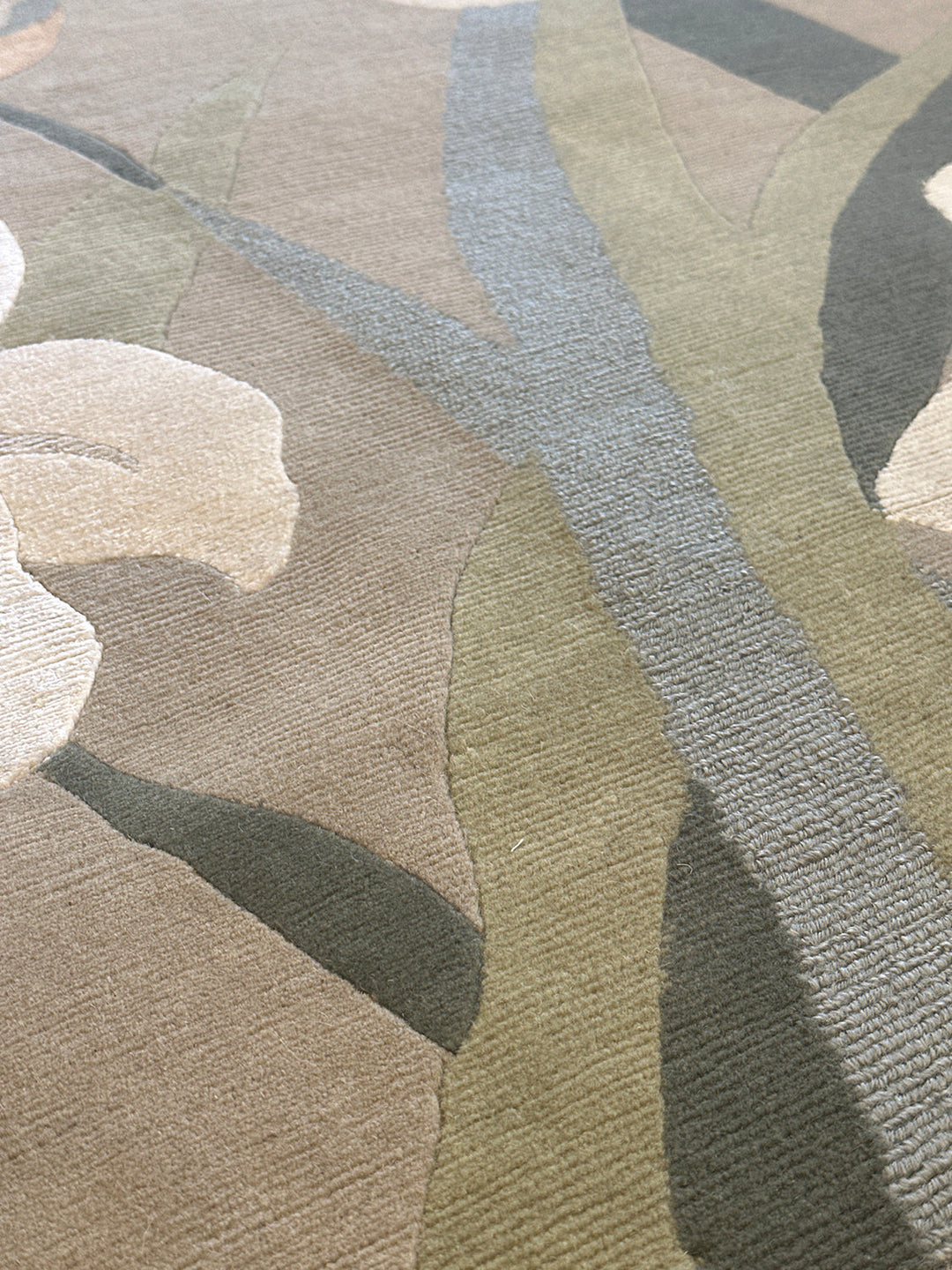 One-of-a-kind 6x9 hand-knotted Tibetan wool and silk rug with a green background and white floral design.