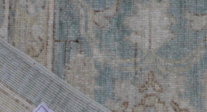 Close-up of a textured rug with intricate patterns in neutral colors.