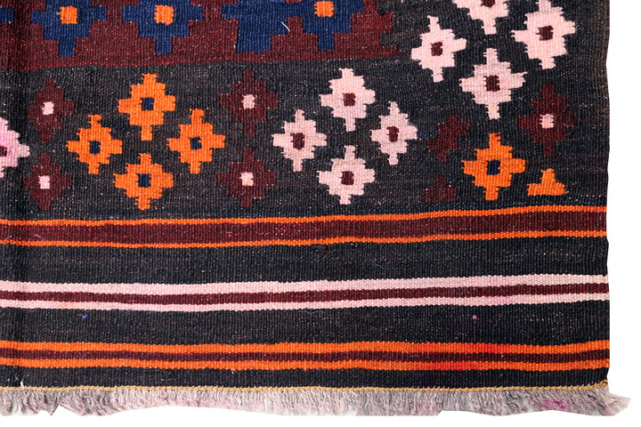 Close-up of a woven fabric with colorful geometric patterns on a white background