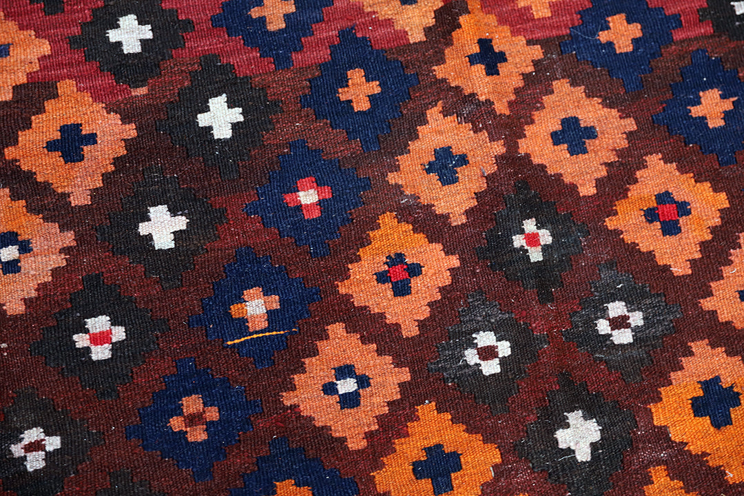 Patterned fabric with geometric design in red, blue, orange, and black.