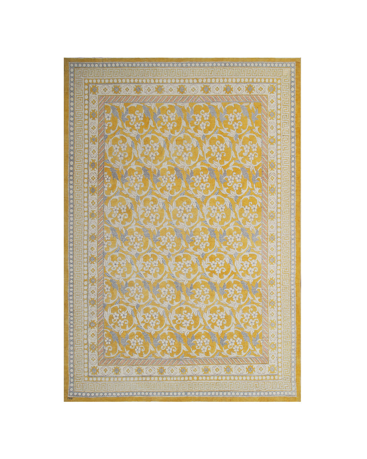 A rectangular area rug with an ornate traditional floral pattern in yellow, beige, and light blue, featuring a decorative border.