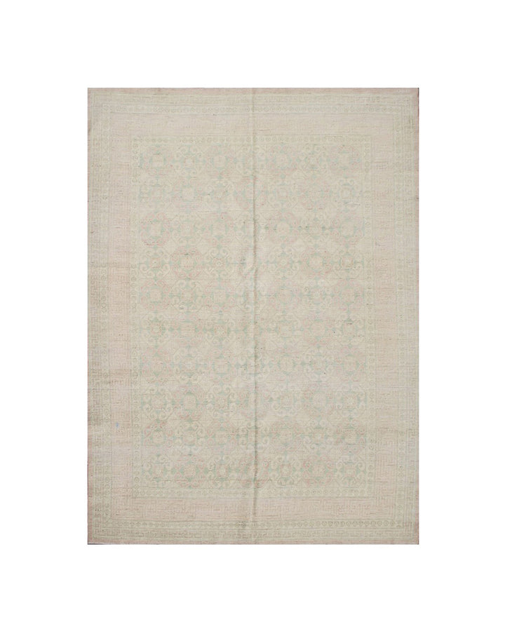 A rectangular area rug with a faded traditional floral pattern in soft beige and muted sage green tones, shown flat against a plain white background.