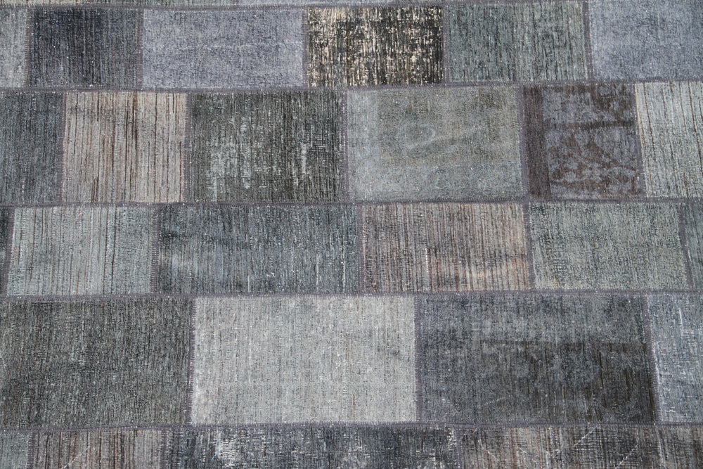 Patchwork rug with various shades of gray and brown