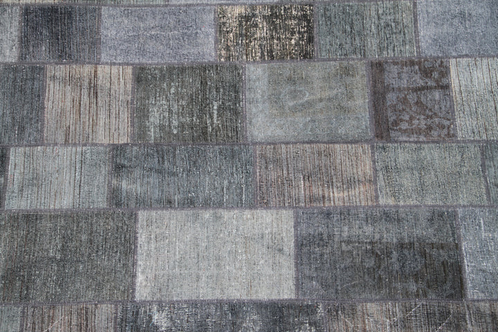 Patchwork rug with various shades of gray and brown