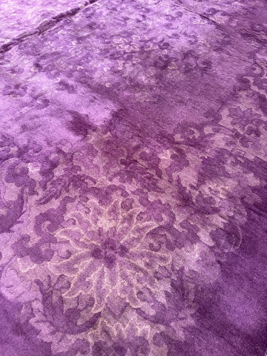 Close-up of a textured purple fabric with floral patterns