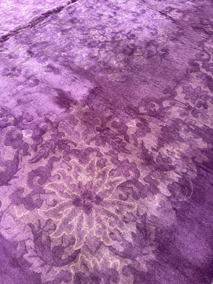 Close-up of a textured purple fabric with floral patterns
