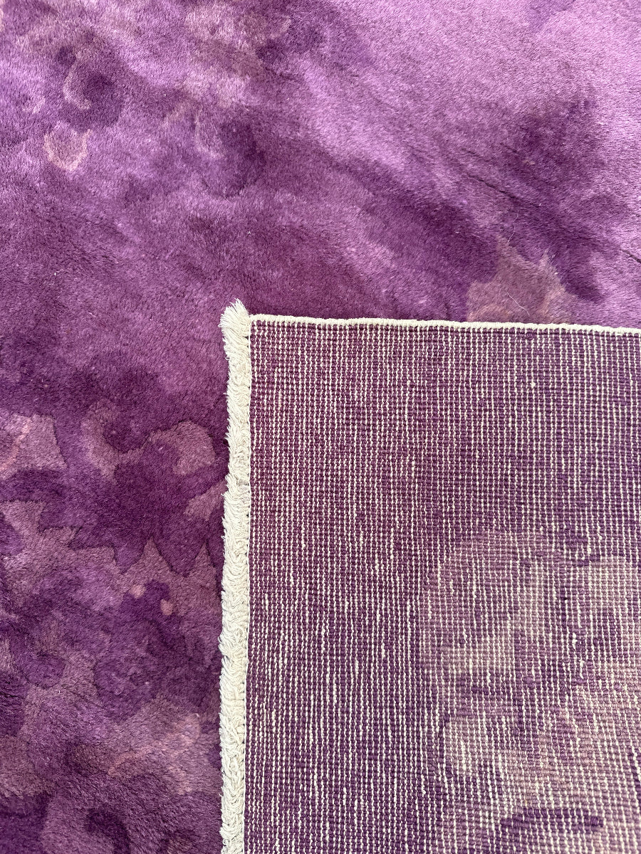 Close-up of a textured purple rug with a visible border.