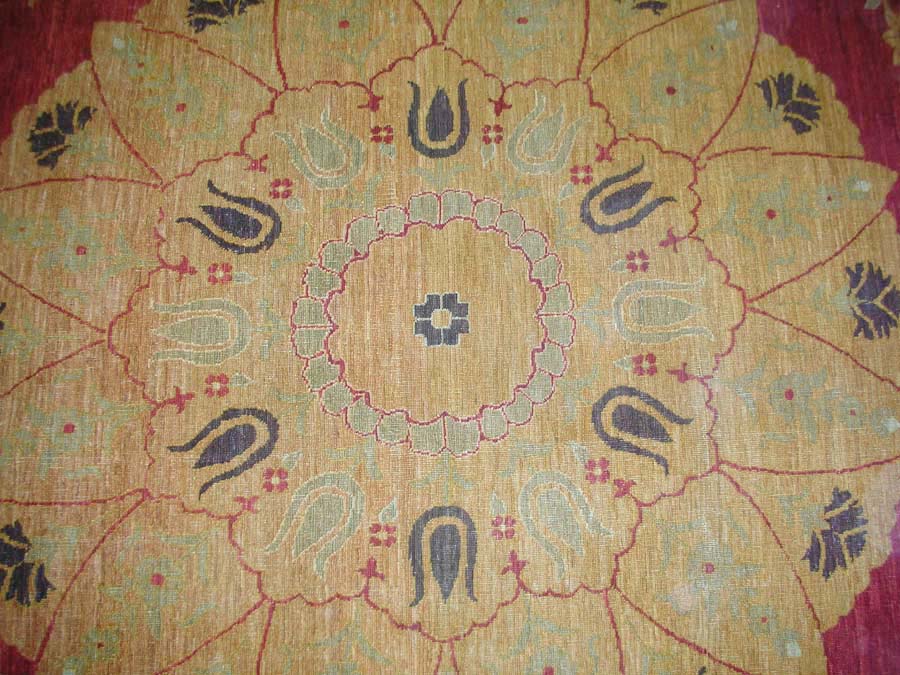 Close-up of a patterned fabric with floral and paisley designs on a red background