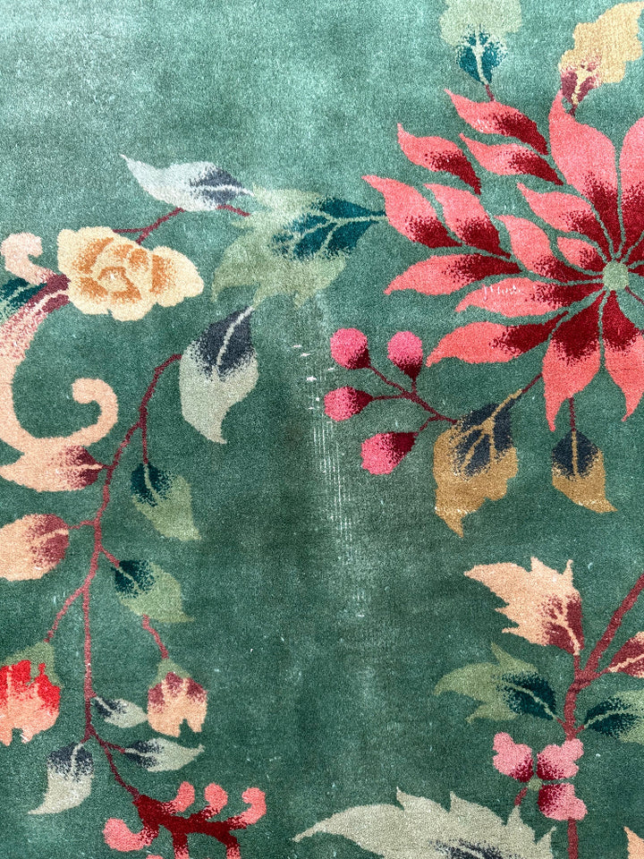 Floral patterned rug with pink, red, and yellow flowers on a green background