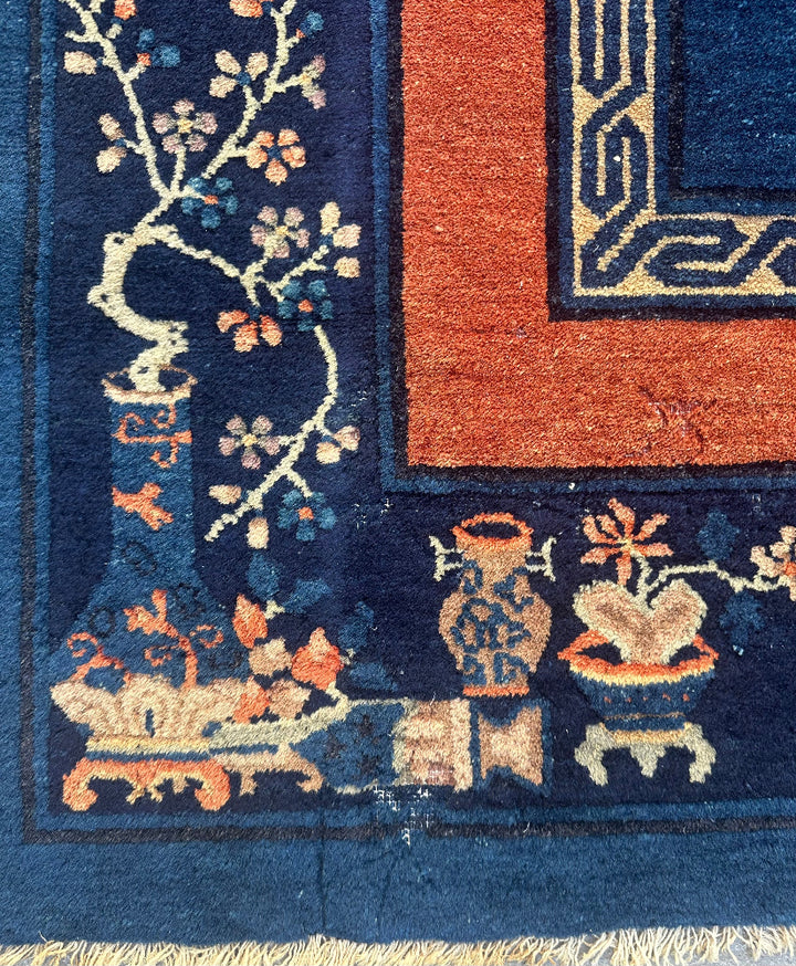 Close-up of a patterned rug with floral and architectural designs.