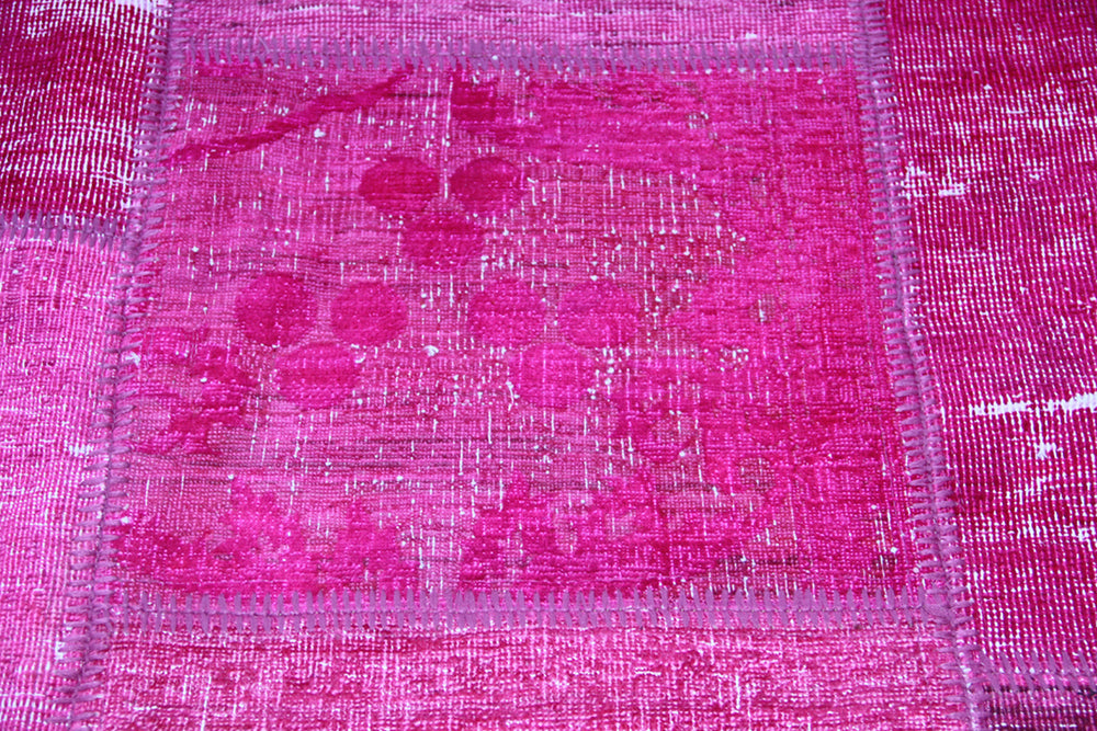Close-up of a pink patchwork fabric with a grid pattern