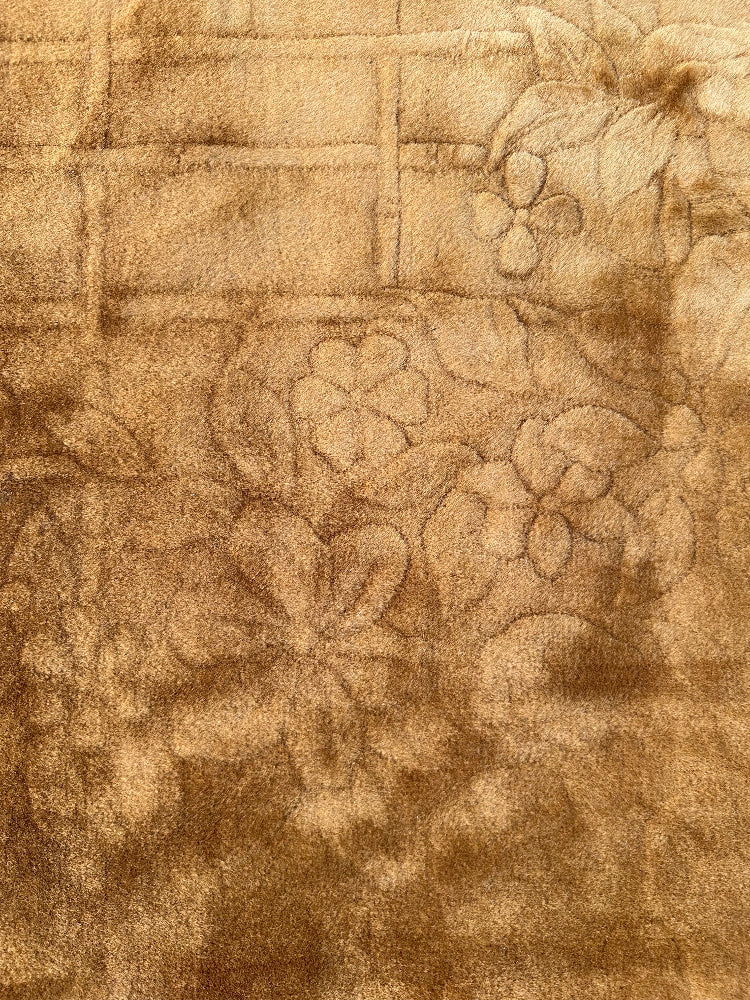 Close-up of textured fabric with floral pattern in brown tones