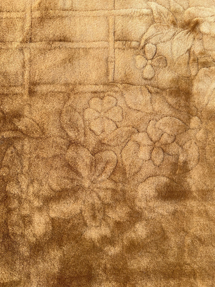 Close-up of textured fabric with floral pattern in brown tones