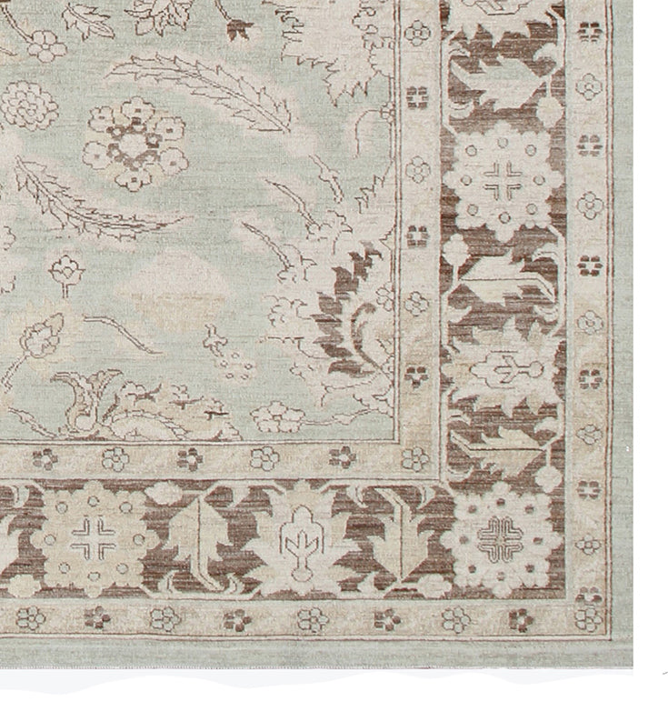 Corner of a decorative rug with intricate patterns on a light background