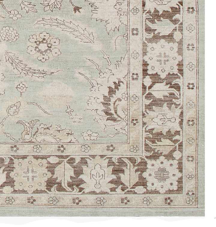 Corner of a decorative rug with intricate patterns on a light background