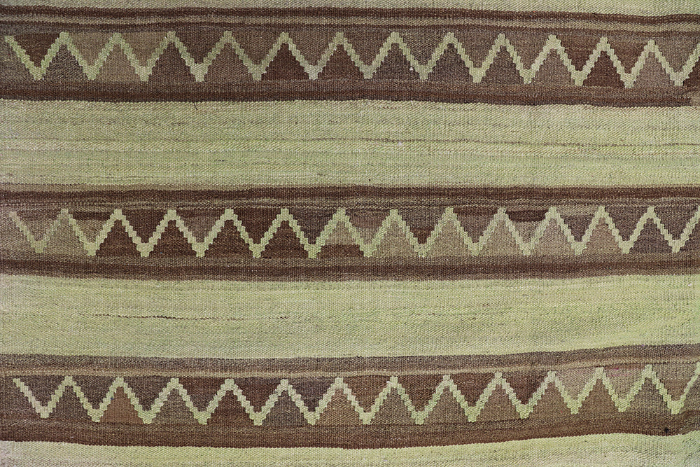 Handwoven green overdyed wool kilim with brown accents and geometric tribal design, crafted by Uzbek artisans in Afghanistan. Luxury flatweave from the Ariana Kilim Collection.
