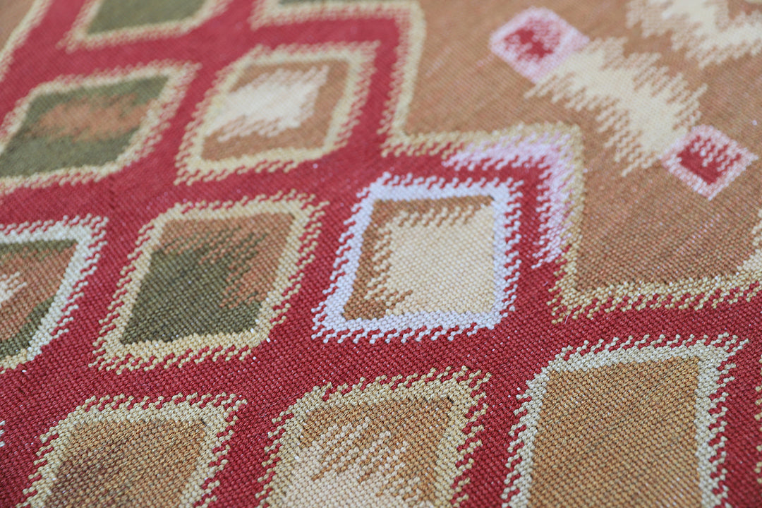 Handwoven modern geometric kilim in red, white, green, and gold, crafted from organic wool by women artisans. Luxury contemporary flatweave from the Ariana Kilim Collection.