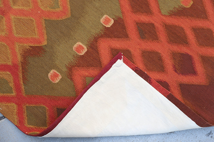 Handwoven modern geometric kilim in red, white, green, and gold, crafted from organic wool by women artisans. Luxury contemporary flatweave from the Ariana Kilim Collection.