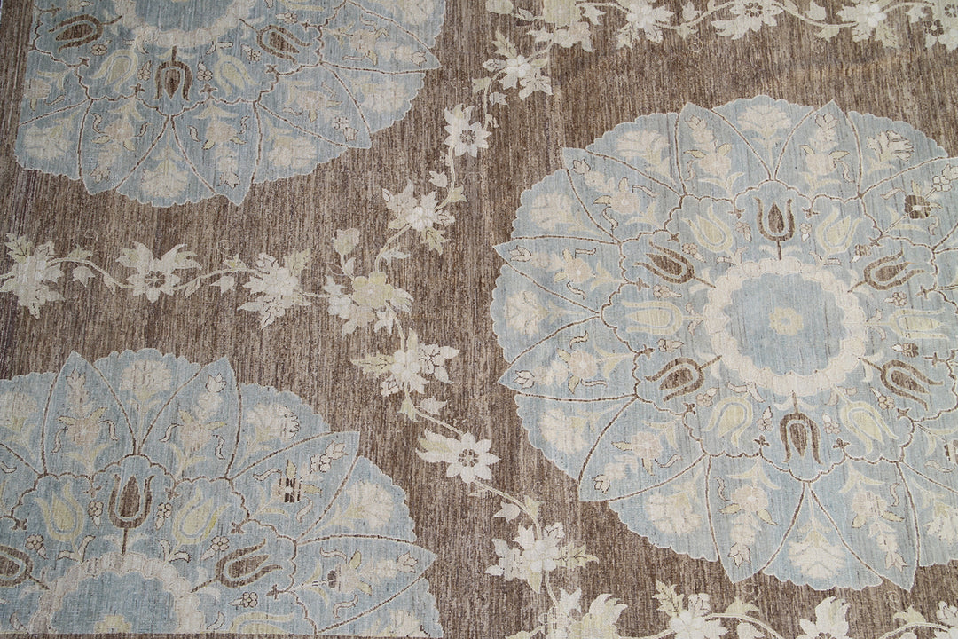 Top-down view of a luxury 9x12 Ariana rug with ivory field, blue and brown Ottoman palmettes, and short wool pile.