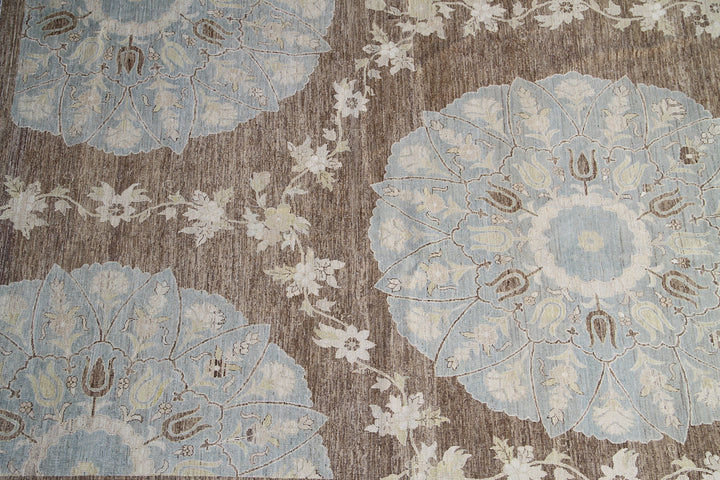 Top-down view of a luxury 9x12 Ariana rug with ivory field, blue and brown Ottoman palmettes, and short wool pile.