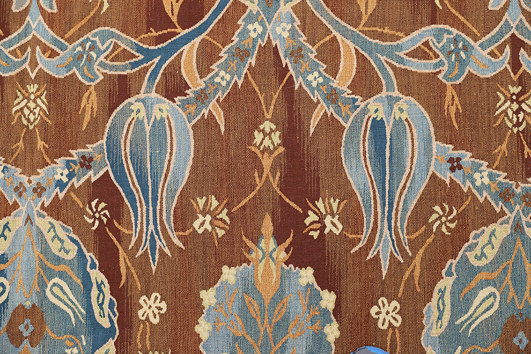 Handwoven Ottoman‑inspired kilim rug in earthy browns and vibrant blues, crafted from organic wool on a cotton foundation by Afghan artisans. High‑end geometric flatweave design.