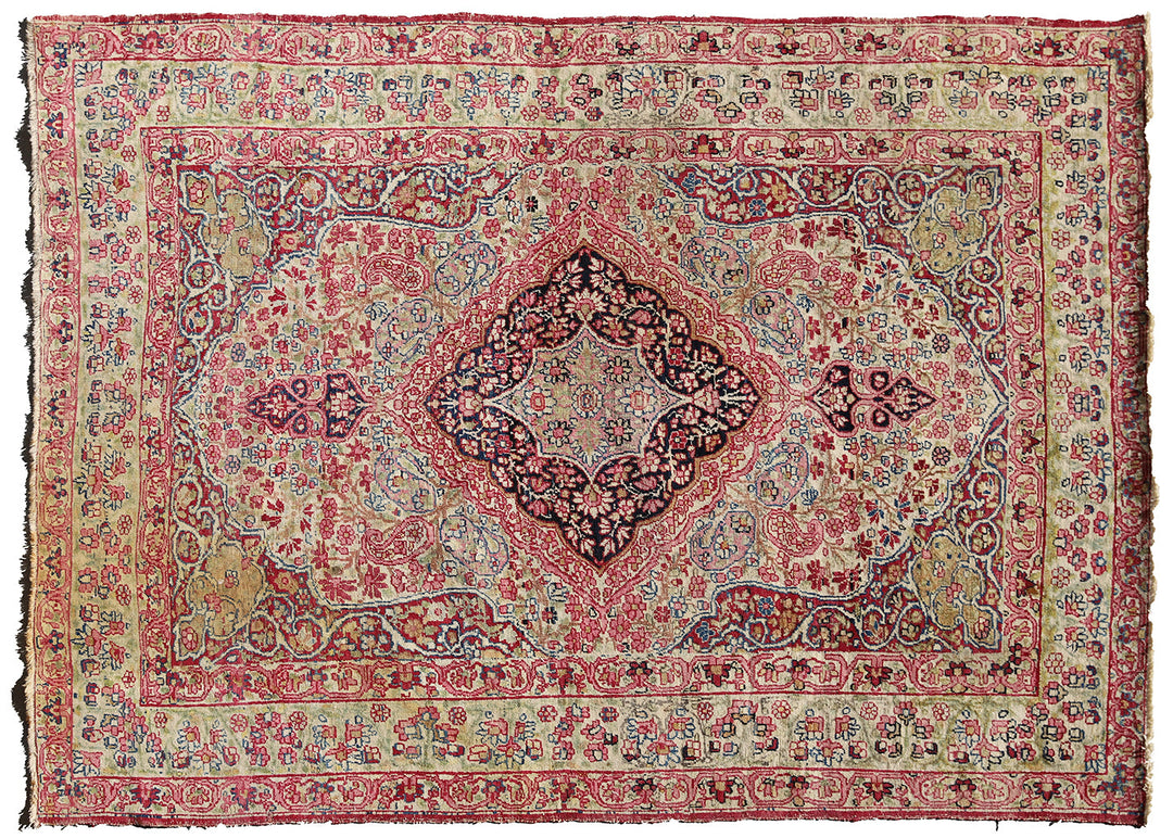 Late 19th-century antique Persian Kermanshah rug featuring a dark navy center medallion on an ivory floral field with pink, red, and blue botanical details