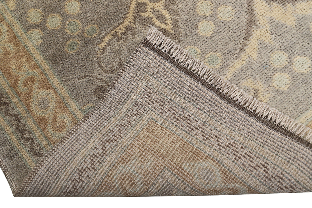Hand-knotted 7' x 9'9" Afghan Oushak rug with an Ottoman design in soft grey, cream, and brown.