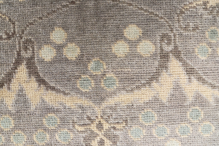 Hand-knotted 7' x 9'9" Afghan Oushak rug with an Ottoman design in soft grey, cream, and brown.