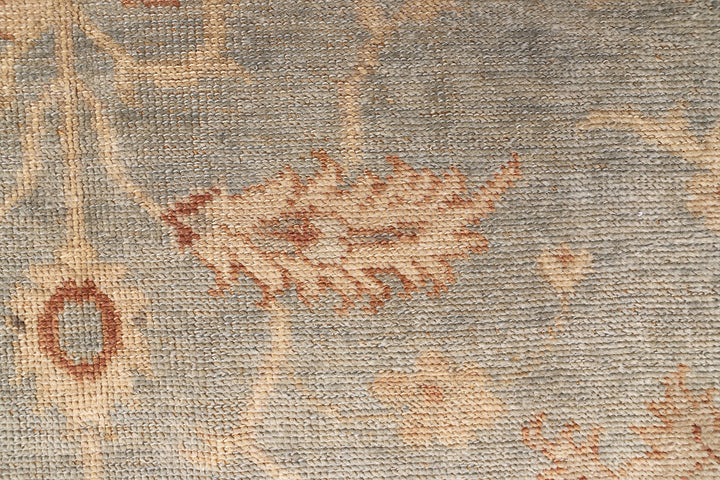 Hand-knotted 8'1" x 9'7" Afghan Oushak rug featuring a soft sky blue field with a sand goldish yellow border and terracotta and cream floral motifs.