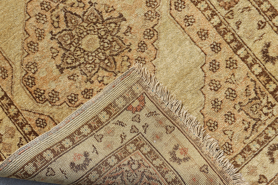 Small antique Haji Jalili design Persian rug featuring tan and gold medallion open field with intricate spandrels and border