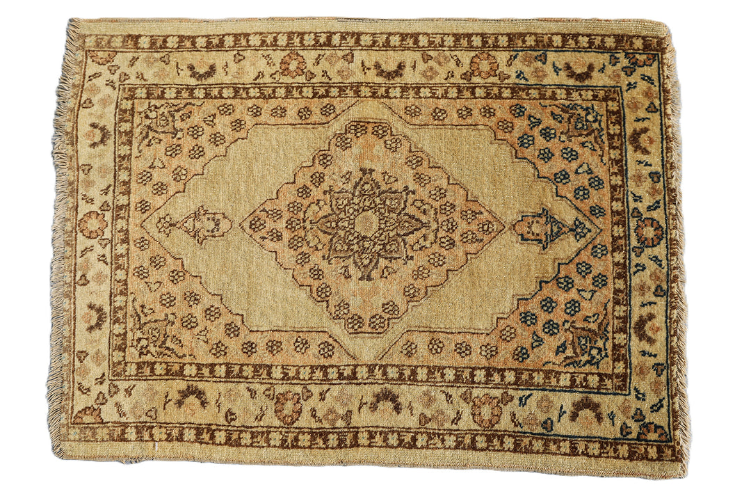 Small antique Haji Jalili design Persian rug featuring tan and gold medallion open field with intricate spandrels and border