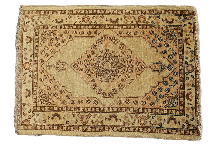 Small antique Haji Jalili design Persian rug featuring tan and gold medallion open field with intricate spandrels and border