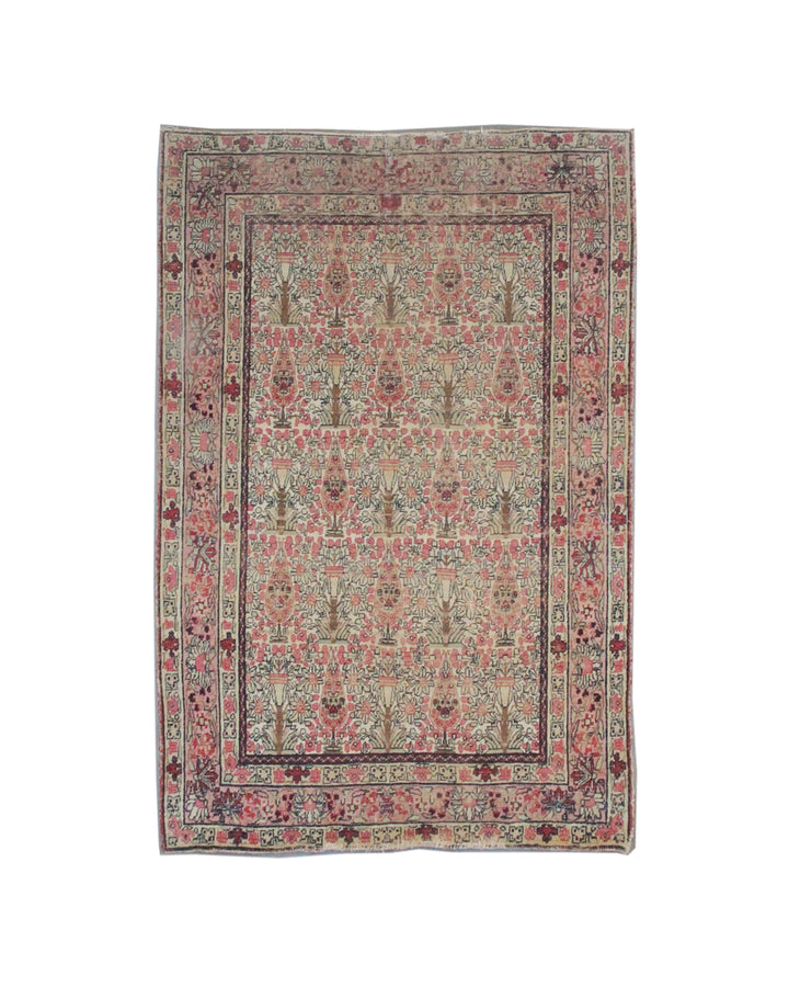 Antique Persian Kerman wool rug featuring an allover floral design with intricate palmettes and vine scrolls in soft pink, ivory, and deep navy blue
