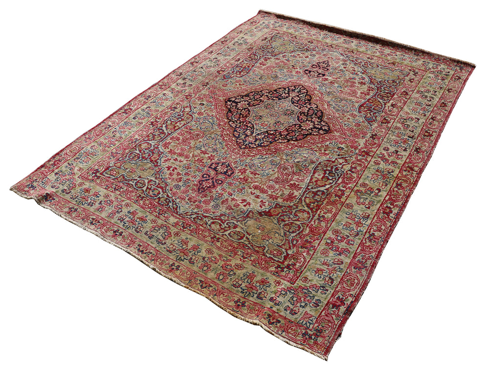 Late 19th-century antique Persian Kermanshah rug featuring a dark navy center medallion on an ivory floral field with pink, red, and blue botanical details