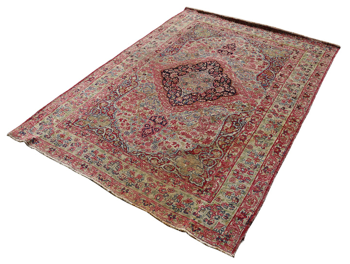 Late 19th-century antique Persian Kermanshah rug featuring a dark navy center medallion on an ivory floral field with pink, red, and blue botanical details