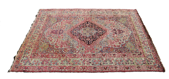 Late 19th-century antique Persian Kermanshah rug featuring a dark navy center medallion on an ivory floral field with pink, red, and blue botanical details