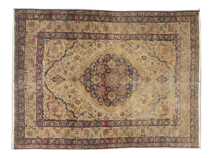Antique Persian Kermanshah wool area rug with a central floral medallion in warm tan and deep navy blue with low pile