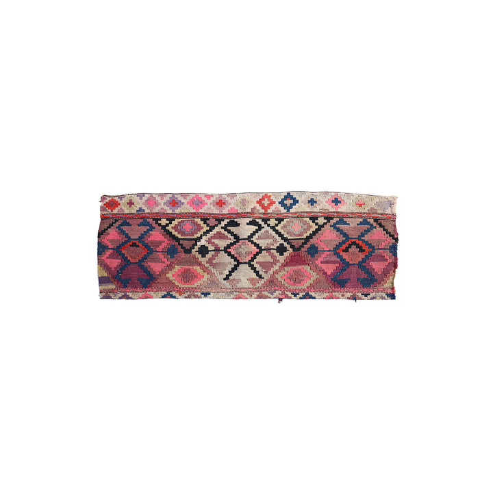 A rectangular vintage kilim rug band with geometric patterns in pink, red, blue, and beige on a white background.