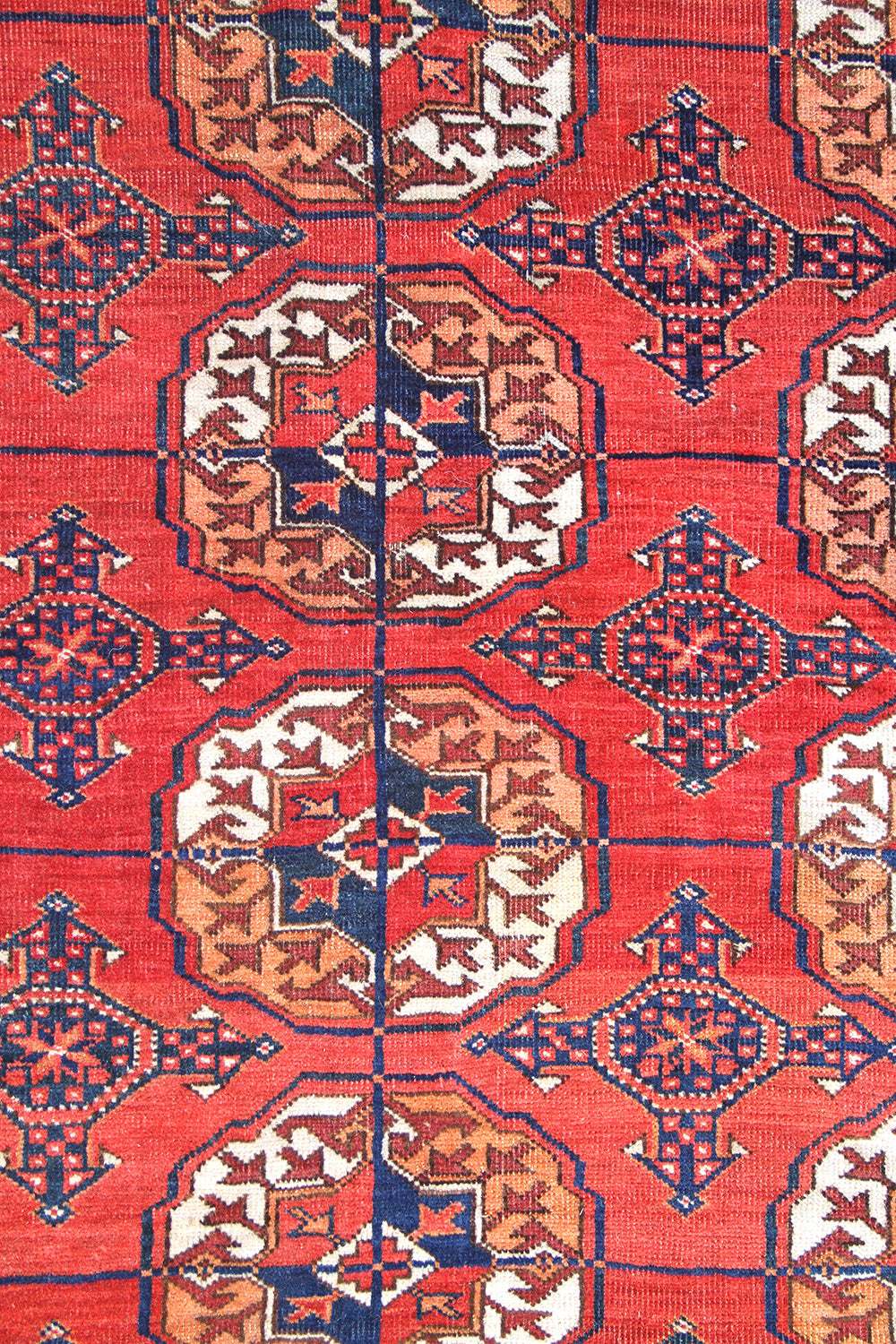 12'2" x 7'6" semi-antique Turkmen main carpet featuring a deep red field with hand-knotted geometric octagonal gul motifs and tribal borders.
