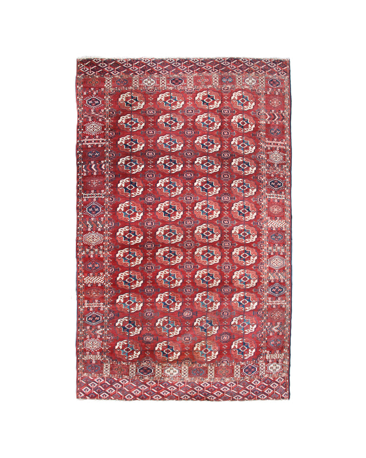 11'1" x 7'1" Antique Turkmen main rug featuring a deep red background with hand-knotted geometric motifs in navy, green, white, and brown.