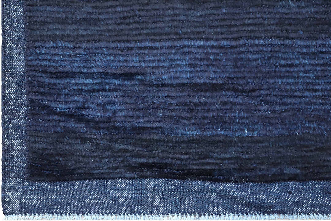 Hand-knotted 6'3" x 9'2" Moroccan-style solid deep blue wool area rug with a rich, soft pile from the Ariana Barchi Collection.