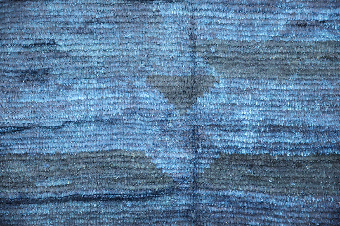 Hand-knotted 6'3" x 9'2" Moroccan-style solid deep blue wool area rug with a rich, soft pile from the Ariana Barchi Collection.