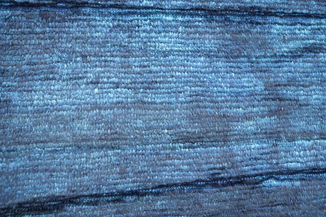 Hand-knotted 6'3" x 9'2" Moroccan-style solid deep blue wool area rug with a rich, soft pile from the Ariana Barchi Collection.