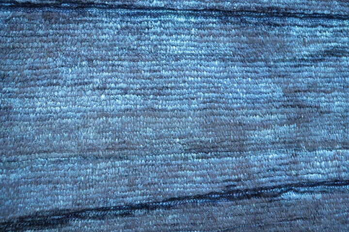 Hand-knotted 6'3" x 9'2" Moroccan-style solid deep blue wool area rug with a rich, soft pile from the Ariana Barchi Collection.