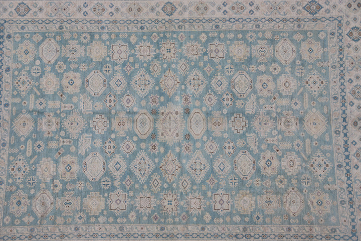 Authentic Ariana Hazara Collection 10x14 wool area rug. Features a geometric Caucasian design with a blue field, black, white, and pink accents, hand-knotted by Hazara women in Afghanistan.