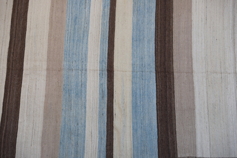 5x7 Ariana Kilim hand-woven Afghan wool rug with blue, white, camel, and brown stripes, full overhead view.