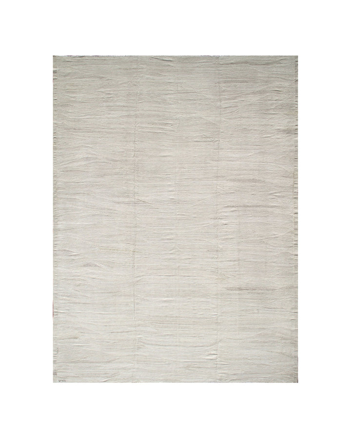 Large earth-tone flatweave Ariana kilim rug in natural undyed organic wool with subtle woven texture.